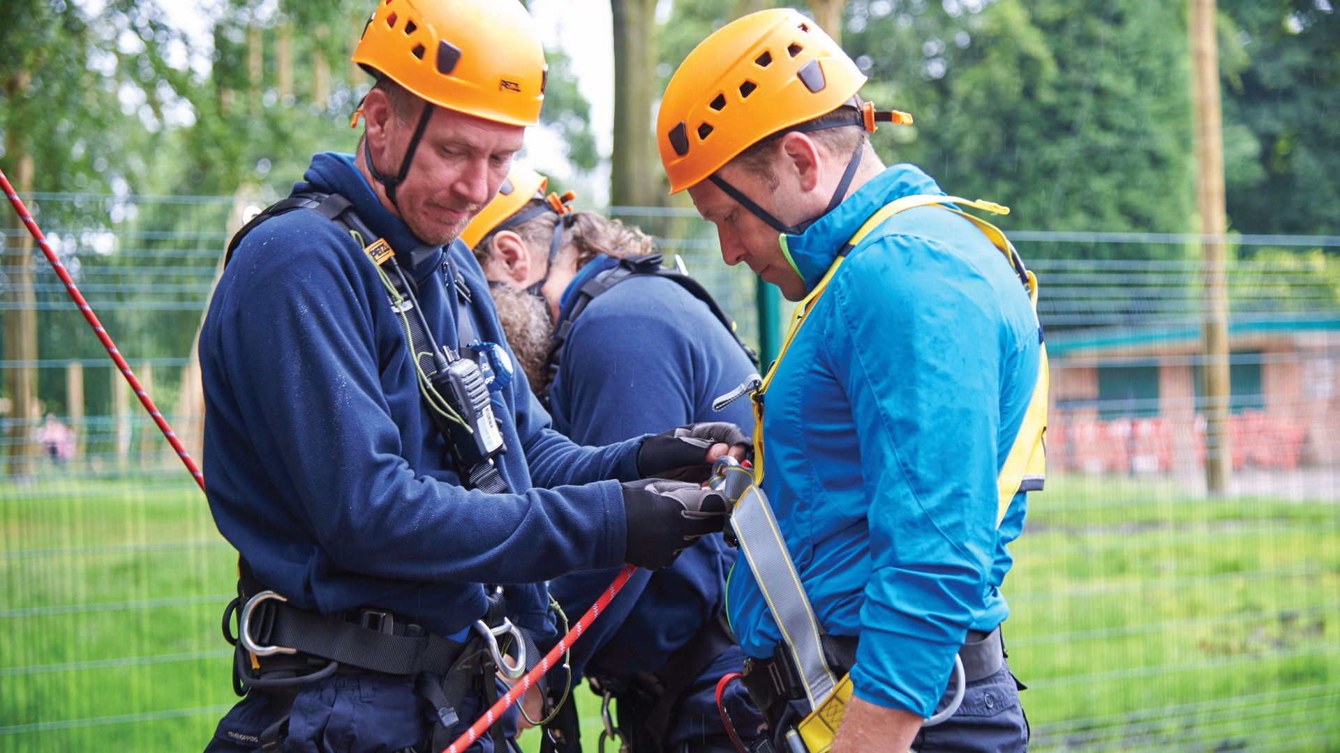An instructor harnessing another man for zip wire
