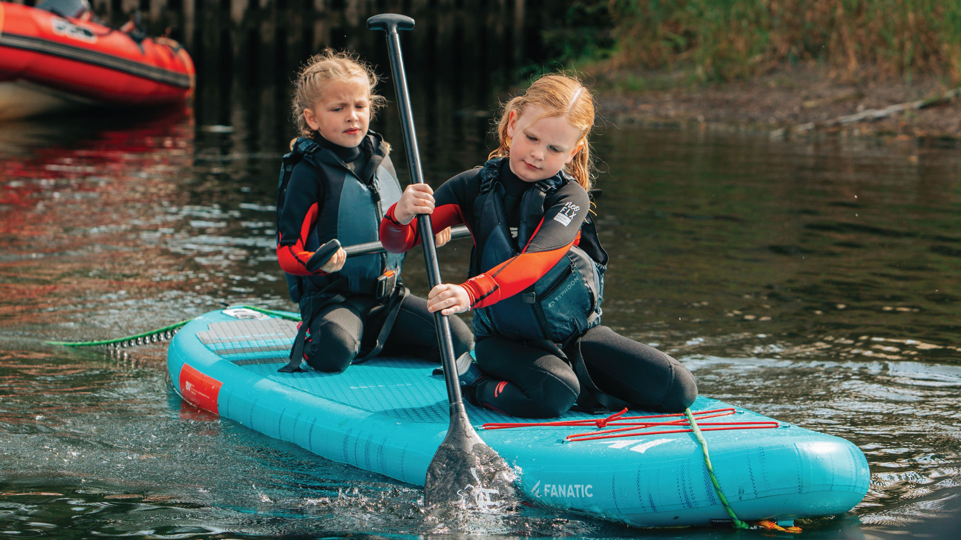 Two children paddleboarding