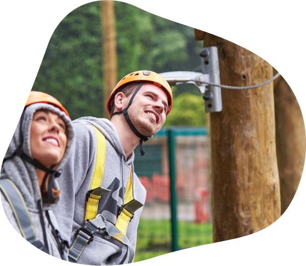 A man and woman wearing portective gear for climbing