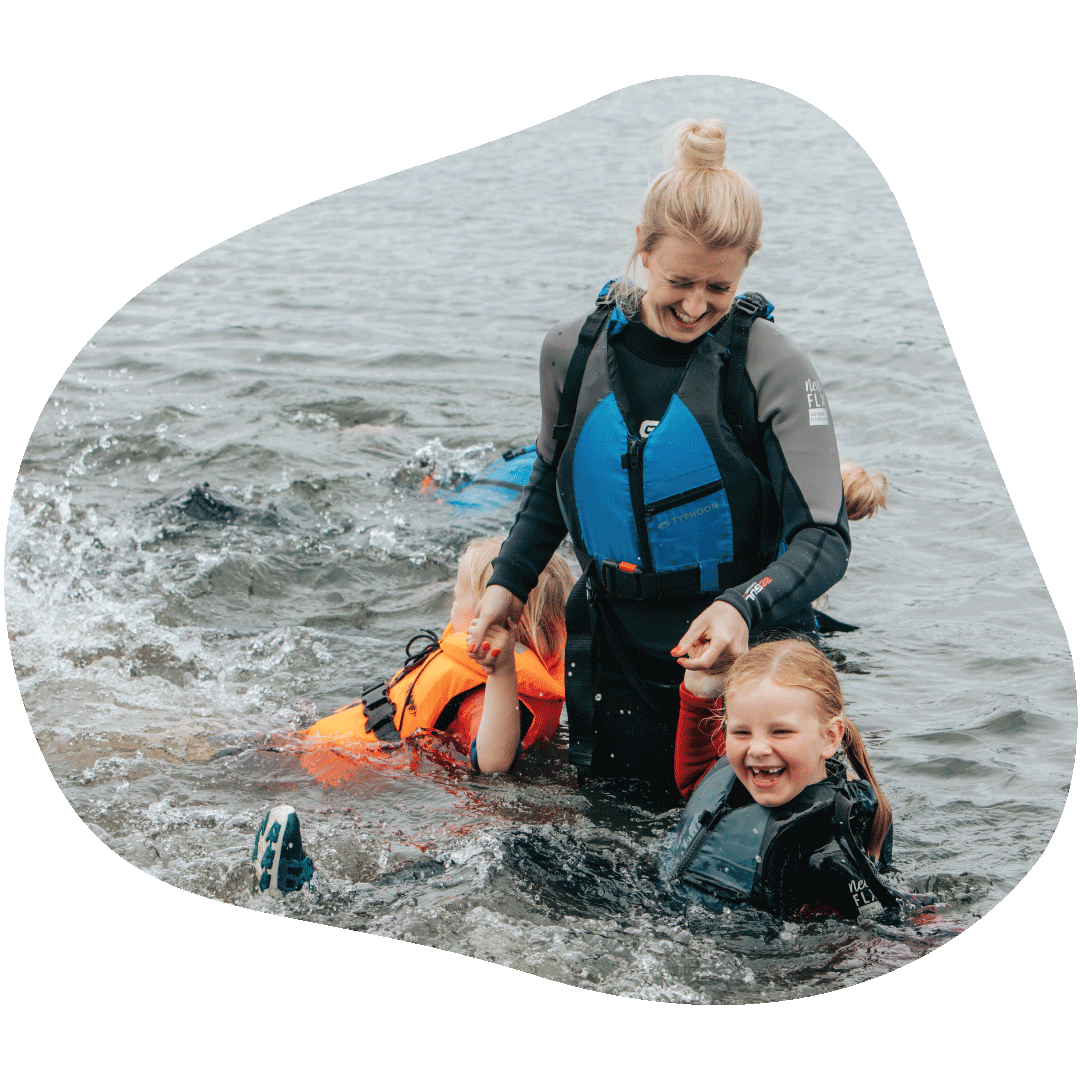 A woman with two children splashing in water